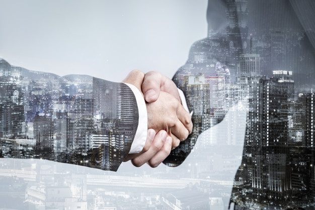Double exposure of business partnership handshake and modern cit